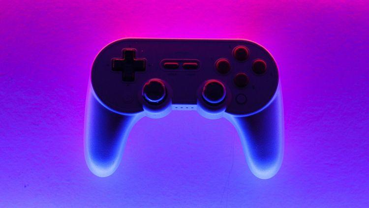 black, blue, red video game controller on a multicoloured background